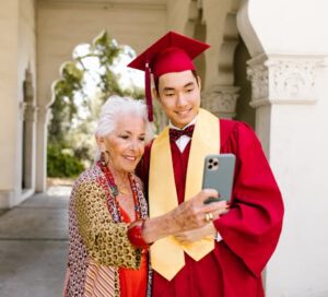 A grandmother taking a selfie with her graduating grandson